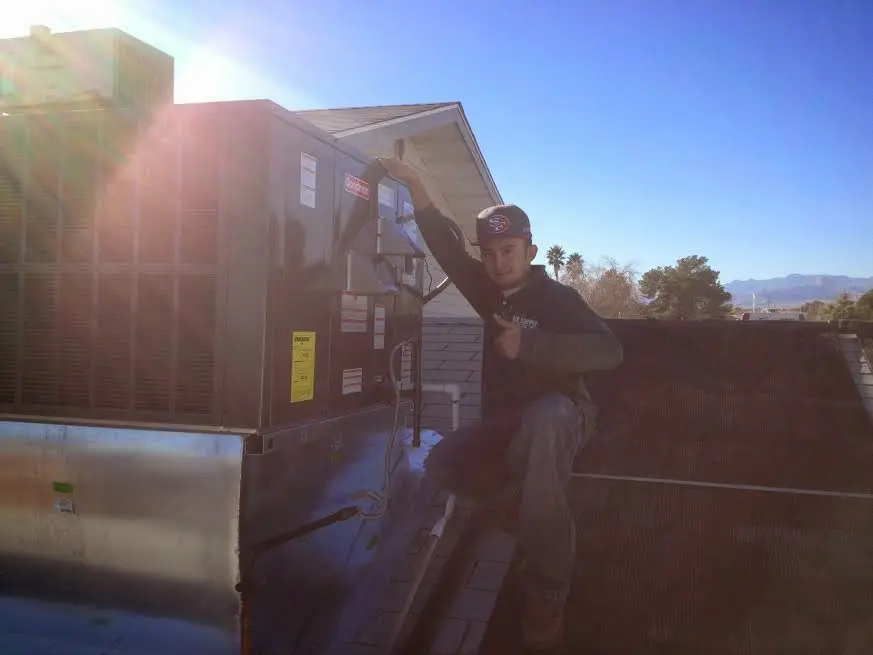 HVAC technician performing AC Tune-Up on a rooftop unit in Prosper